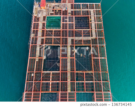 Construction project on a large platform over the water during daytime in a coastal area showing cleared sections and materials 136734145