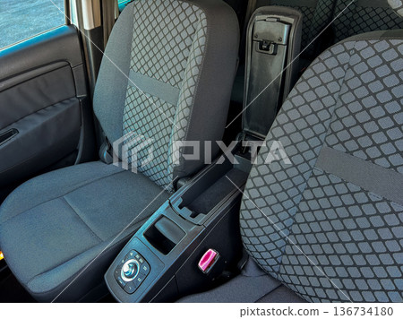 Front seats of a car showing a center console with storage space and control features in a clean vehicle interior taken during daylight Front seats of a car showing a center console with storage space and control features in a clean vehicle interior taken during daylight 136734180