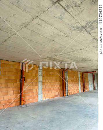 Construction area shows unfinished walls and pipes in a building project located in an urban environment during daylight hours Construction area shows unfinished walls and pipes in a building project located in an urban environment during daylight hours 136734213