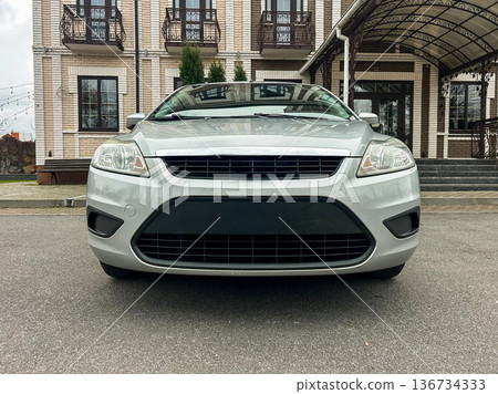 Car parked in front of a building during daytime showing an urban setting and clear weather with no people visible around Car parked in front of a building during daytime showing an urban setting and clear weather with no people visible around 136734333