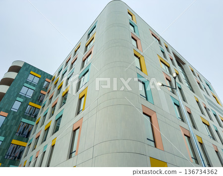 Modern building with colorful panels located in an urban area during overcast weather 136734362