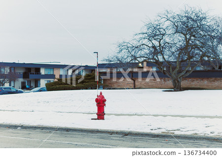 Hydrant stands by a snowy area near buildings in a neighborhood on a cold day Hydrant stands by a snowy area near buildings in a neighborhood on a cold day 136734400