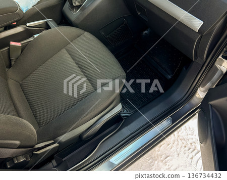 Interior view of a car showing a driver's seat and dashboard area in a parked vehicle on a sunny day Interior view of a car showing a driver's seat and dashboard area in a parked vehicle on a sunny day 136734432
