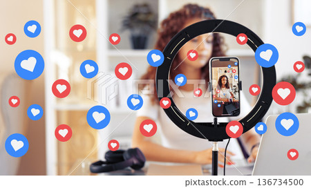 Podcaster filming episode with social media reactions while working at desk in home office 136734500