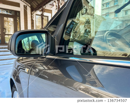 Close view of a car side mirror and building during winter season in an urban area 136734507