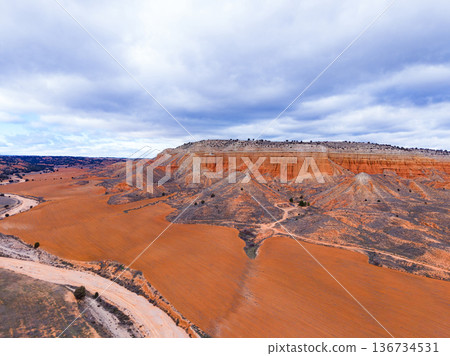 Canyon view in Teruel with orange land and hills under a cloudy sky during the day providing a scenic landscape 136734531