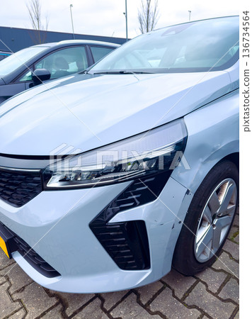 Car with damage parked in a lot near a building during daytime 136734564