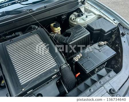 Close view of car engine with highlighted parts and components during a routine inspection at a garage on a sunny day 136734640