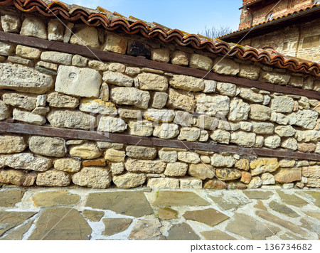 Old stone wall with wooden beams under blue sky in historical location during daytime 136734682