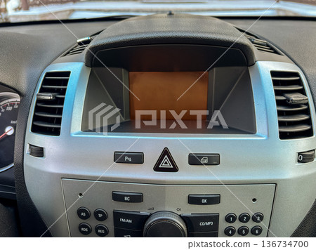 Dashboard view of a car's audio and control system in a modern vehicle at midday 136734700