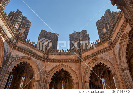 Architectural detail of the unfinished chapel in Batalha with Gothic tracery and pinnacles on a clear, monumental day 136734770
