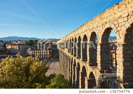 Majestic arches of Segovia aqueduct under a clear blue sky 136734779