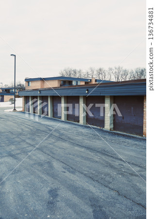 Rows of closed garage doors along a paved road in a storage area on a cloudy day in a suburban neighborhood Rows of closed garage doors along a paved road in a storage area on a cloudy day in a suburban neighborhood 136734881