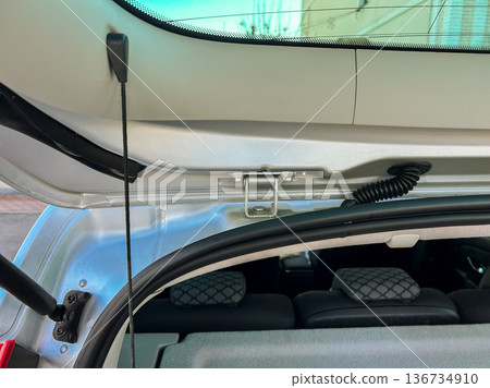 Car trunk with open lid shows storage space and interior view at a parking area on a sunny day Car trunk with open lid shows storage space and interior view at a parking area on a sunny day 136734910