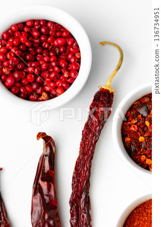 Red spices and peppers are arranged on a white surface for cooking or seasoning food Red spices and peppers are arranged on a white surface for cooking or seasoning food 136734951