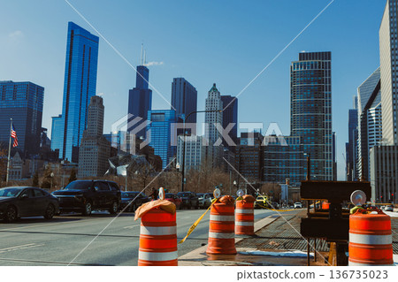 Construction work takes place on a city street in Chicago with tall buildings in the background under clear blue sky 136735023