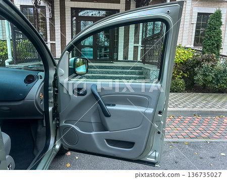 Car door open showing interior in front of building with stairs and plants on a sunny day Car door open showing interior in front of building with stairs and plants on a sunny day 136735027
