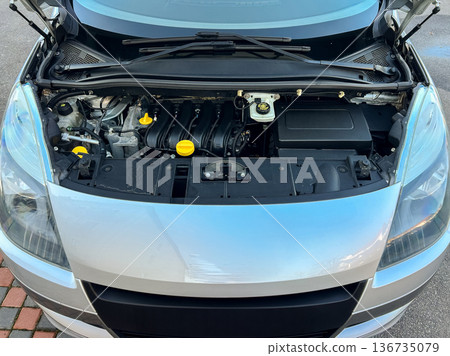 Car engine displayed open at a service area with tools nearby during a morning inspection showing maintenance and repair process Car engine displayed open at a service area with tools nearby during a morning inspection showing maintenance and repair process 136735079