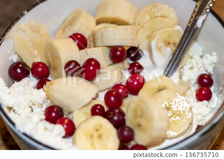 Cottage cheese mixed with bananas and cranberries in a bowl Cottage cheese mixed with bananas and cranberries in a bowl 136735710