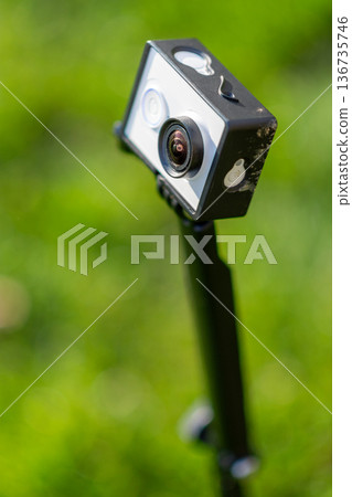Action camera on selfie stick outdoors with bokeh background Action camera on selfie stick outdoors with bokeh background 136735746