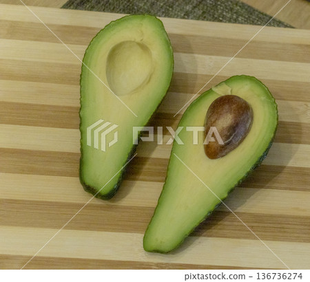 Shot of avocado cut in half on the wooden cutting board 136736274