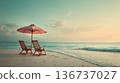Two wooden deck chairs under umbrella on beach 136737027