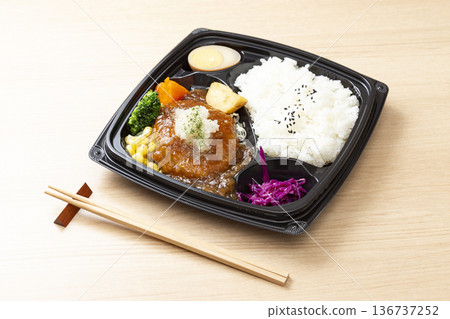 A Japanese-style hamburger steak bento box placed on the table A Japanese-style hamburger steak bento box placed on the table 136737252