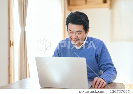 Senior Asian man using a computer Senior Asian man using a computer 136737665