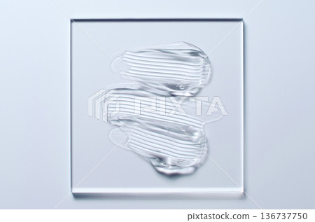 A sample of a transparent cosmetic skin care product on glass. Blue background A sample of a transparent cosmetic skin care product on glass. Blue background 136737750
