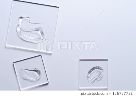 A sample of a transparent cosmetic skin care product on glass. Blue background A sample of a transparent cosmetic skin care product on glass. Blue background 136737751