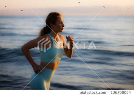 Sporty young woman is running against sea background during her vacation. Freedom and summer sport concept Sporty young woman is running against sea background during her vacation. Freedom and summer sport concept 136738094