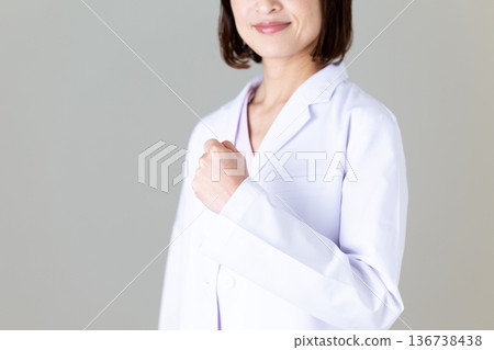 一位身穿白大褂的中年女醫生揮拳 一位身穿白大褂的中年女醫生揮拳 136738438