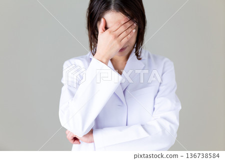 一位身穿白大褂、神情憂慮的中年女醫生 136738584