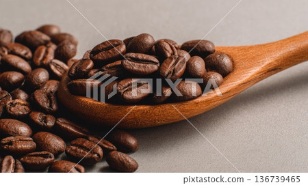 Roasted coffee beans in wooden spoon close up on neutral background Roasted coffee beans in wooden spoon close up on neutral background 136739465