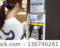 一名女子正在超市的飲水機接水。 136740281