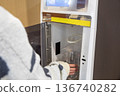 一名女子正在超市的飲水機接水。 136740282
