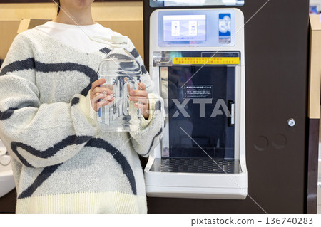 一名女子正在超市的飲水機接水。 136740283