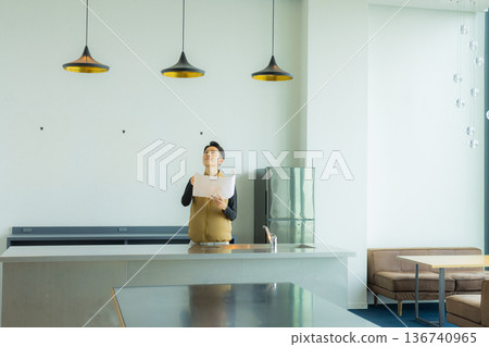 A male craftsman in an air-conditioned suit checking the site while looking at documents 136740965