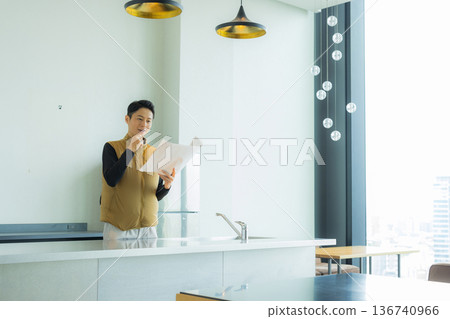 A male craftsman in an air-conditioned suit checking the site while looking at documents 136740966