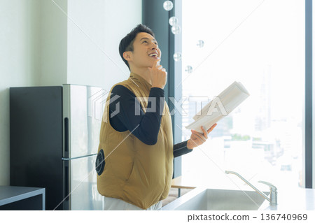 一位身穿空調服的男工匠正在檢查工地文件並進行檢查。 一位身穿空調服的男工匠正在檢查工地文件並進行檢查。 136740969