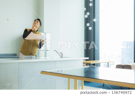 一位身穿空調服的男工匠正在檢查工地文件並進行檢查。 一位身穿空調服的男工匠正在檢查工地文件並進行檢查。 136740972