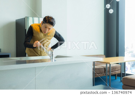 一位身穿空調服的男工匠正在檢查工地文件並進行檢查。 136740974