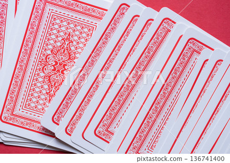 Playing cards lined up on a red background Playing cards lined up on a red background 136741400