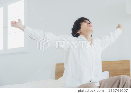 Young man relaxing in bedroom Young man relaxing in bedroom 136741607