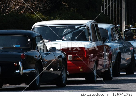 一排老式跑車,包括阿爾法·羅密歐和凱旋,行駛在公共道路上 一排老式跑車,包括阿爾法·羅密歐和凱旋,行駛在公共道路上 136741785
