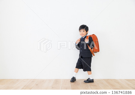 一個穿著西裝、背著書包的男孩 136741886