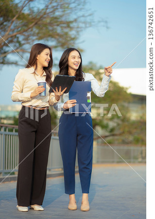 Business team walking and talking on street in city Outside Office and drinking coffee together, partners, teamwork. Business team walking and talking on street in city Outside Office and drinking coffee together, partners, teamwork. 136742651