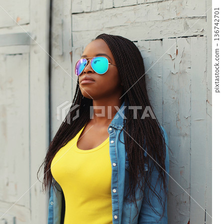 Fashionable young African woman in casual clothing, stylish modern black girl posing in the city Fashionable young African woman in casual clothing, stylish modern black girl posing in the city 136742701