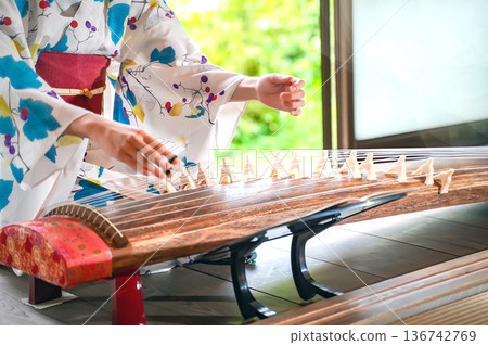 一位身穿浴衣的女子正在彈奏箏。 一位身穿浴衣的女子正在彈奏箏。 136742769