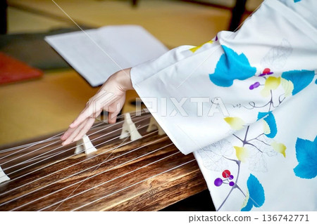 A woman playing the koto in a yukata A woman playing the koto in a yukata 136742771
